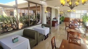 A restaurant with a terrace area, tables, and chairs. - FBK Guest House  (Addis Ababa)