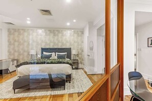 Een moderne slaapkamer met een groot bed, nachtkastjes en een houten vloer.