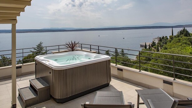 A hot tub on a balcony with a view of a lake and mountains. - Apartman Kira 2 (Dramalj)