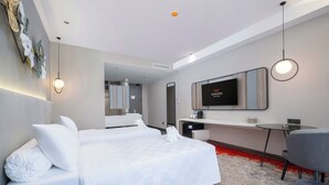 A modern hotel room with a large bed, a desk, a chair, and a TV. - Wahid Prime Hotel Salatiga (Salatiga)