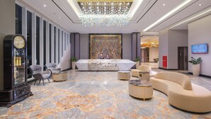 A lobby with a marble floor, a reception desk, and modern seating. - Wahid Prime Hotel Salatiga (Salatiga)