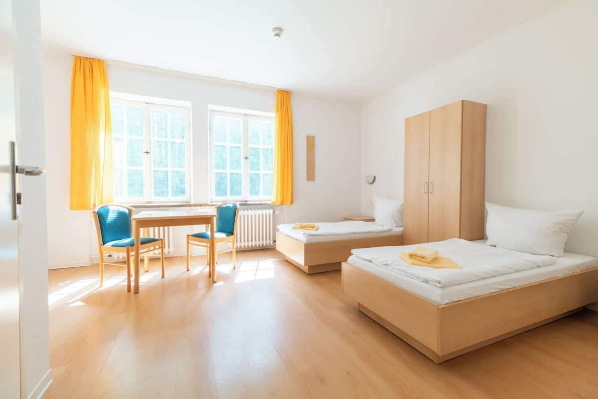 Une chambre avec deux lits, un bureau et une chaise.