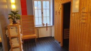 Een gang met een houten bankje, een handdoekhouder en een raam met uitzicht op bomen.
