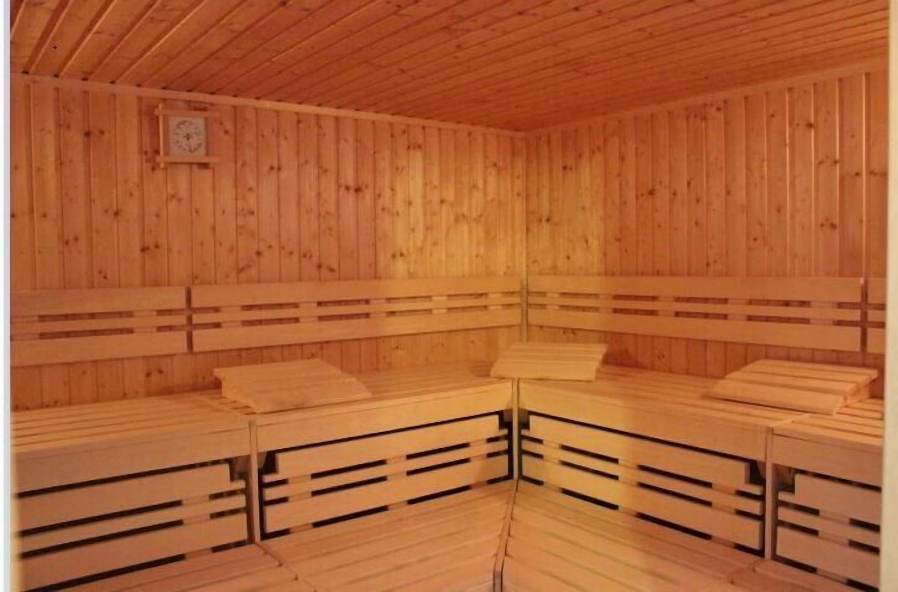 Una sauna de madera con bancos y techo de madera.