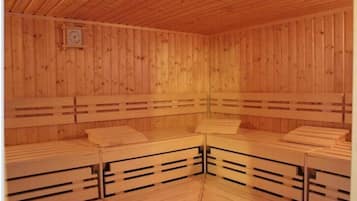 Una sauna de madera con bancos y techo de madera.
