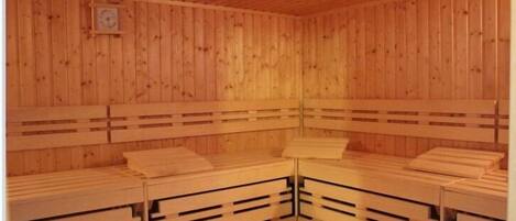 Una sauna de madera con bancos y techo de madera.