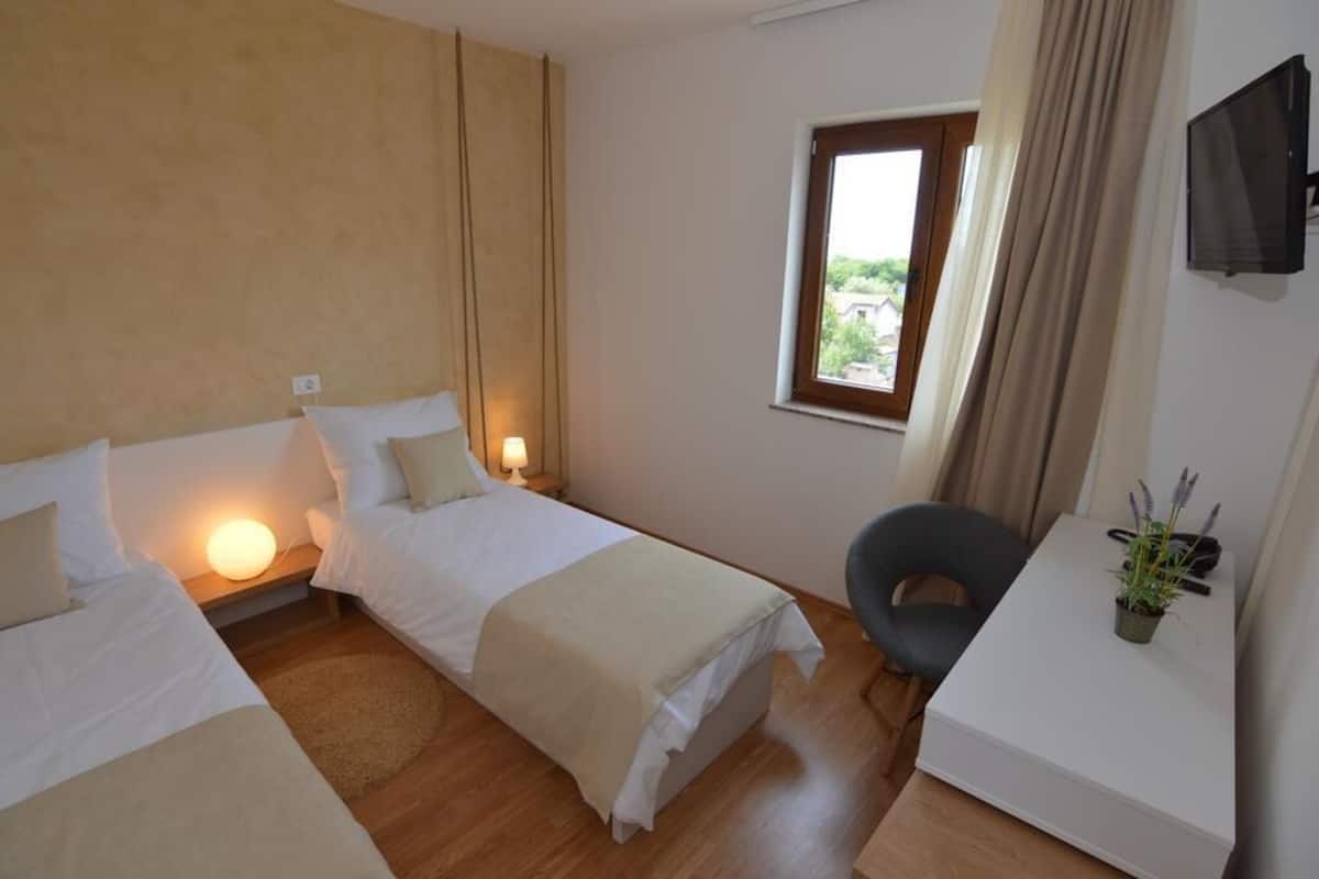 Habitación con 2 camas individuales, balcón, vista parcial al mar | 1 habitación, artículos del minibar gratis, wifi gratis y ropa de cama