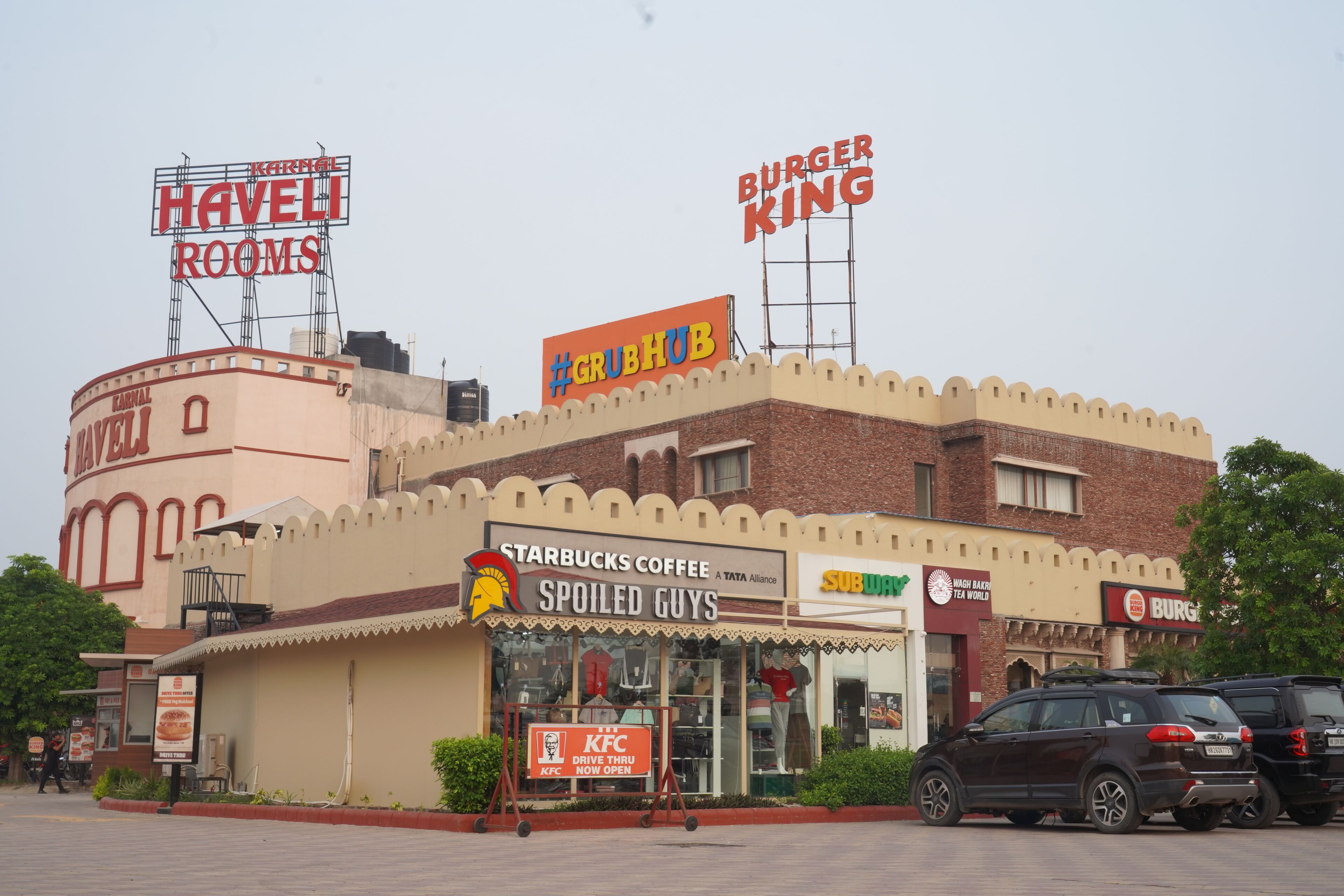 A building with multiple restaurant signs including KFC, Burger King, and Starbucks.