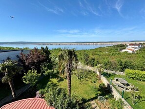 A coastal landscape with a clear sky, a body of water, and a view of a distant shoreline. - Apartment Fruky (Jadranovo)