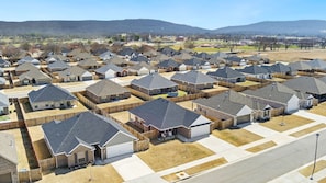 Un quartier résidentiel composé de plusieurs maisons, chacune ayant un garage et une cour clôturée.