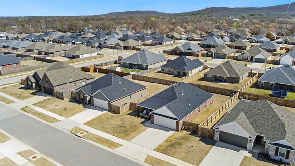 A residential area with multiple houses, each with a garage and a fenced yard.