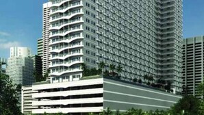 Un immeuble de grande hauteur au design moderne, doté de nombreux balcons et d’une structure d’angle remarquable.