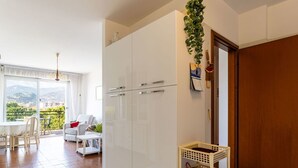Een modern appartement met een balkon, witte kasten en een houten deur.