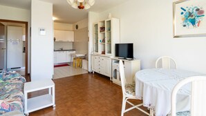 Een compacte woonruimte met kitchenette, eethoek en slaapkamer.