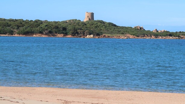 A coastal view with a castle on a hill, clear blue water, and a sandy beach. - Wonderful private villa for 6 people with WIFI, TV, patio and pets allowed (Aglientu)