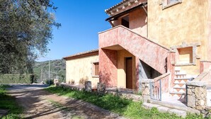 A rustic building with a dirt path leading to a stone staircase. - Cosy apartment for 6 guests with A/C, WIFI, TV, patio and pets allowed (Budoni)