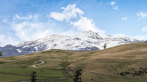 Un paysage de montagne avec une route sinueuse et un ciel dégagé.