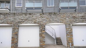 A two-story building with a stone facade and a set of three white garage doors.