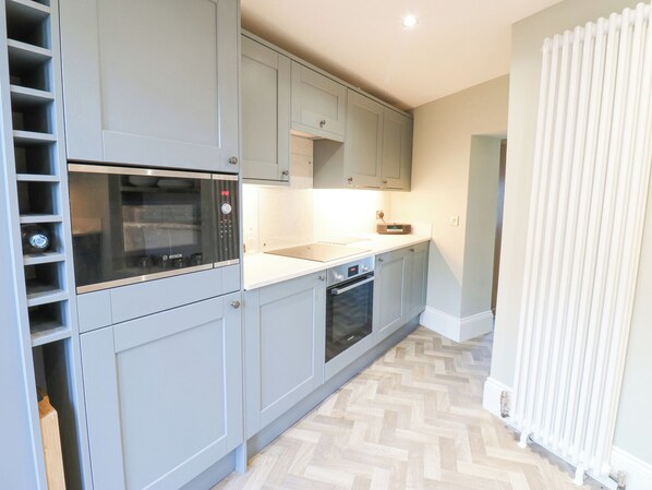 A modern kitchen with grey cabinets, a Bosch microwave, and a built-in oven. - Valley View (Leyburn)