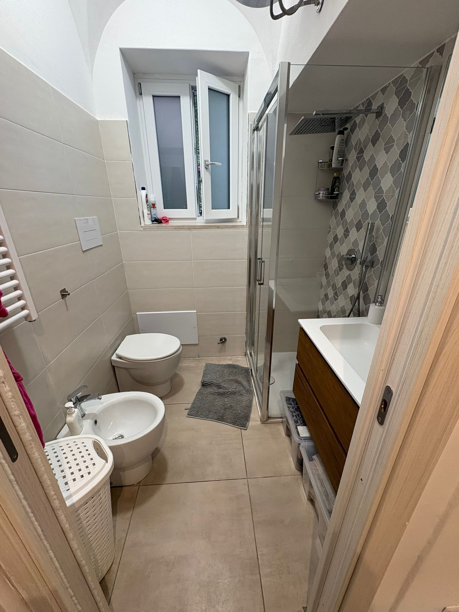 Ein kleines Badezimmer mit Toilette, Bidet, Waschbecken und Duschbereich.