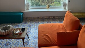 A room with a large window overlooking a coastal landscape, a woven ceiling light, and a patterned floor. - Heartbreaking sea View House in Capri - Italy (Capri)