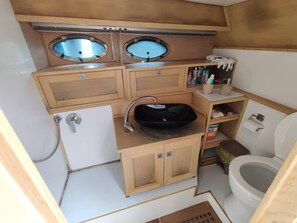 Features two oval sinks, a toilet, and ample storage.
