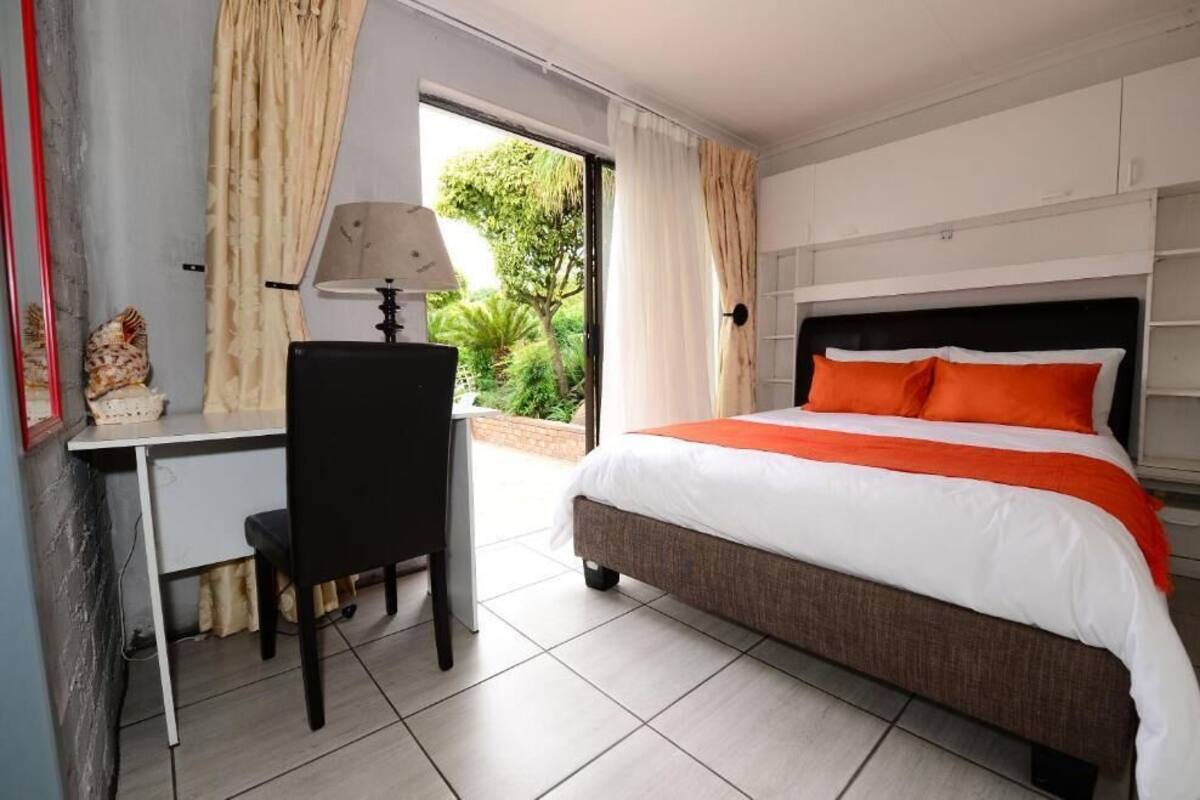 A hotel room with a bed, a desk, and a chair.