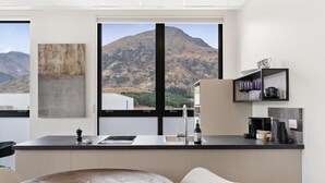 Een moderne keuken met een groot raam, een ronde eettafel en een minimalistisch design.