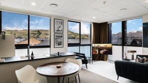 Une chambre d’hôtel moderne dotée d’un coin cuisine, d’une table à manger et d’un espace salon.