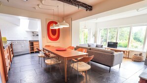 A spacious kitchen with a dining area, a sofa, and a TV. - Tower Cottage (Windermere)