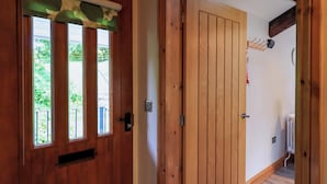A wooden door with a window, a wall-mounted coat hook, and a radiator. - Abbots Reading Mews 2 (Ulverston)