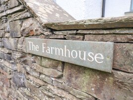 Un muro de piedra con un letrero que dice "The Farmhouse".