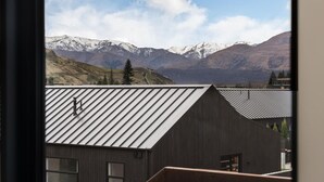 Un edificio moderno con techo inclinado y vista a montañas nevadas.