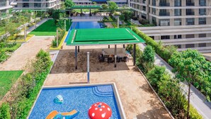 A modern residential complex with high-rise buildings, a swimming pool with a slide, and a green-roofed pavilion. - Executive 1 Br -Gtc with gym & Pool (Nairobi)