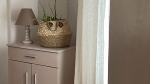 A lamp and a woven basket with a plant on a cabinet. - Casa Di Porto (Kerkira)