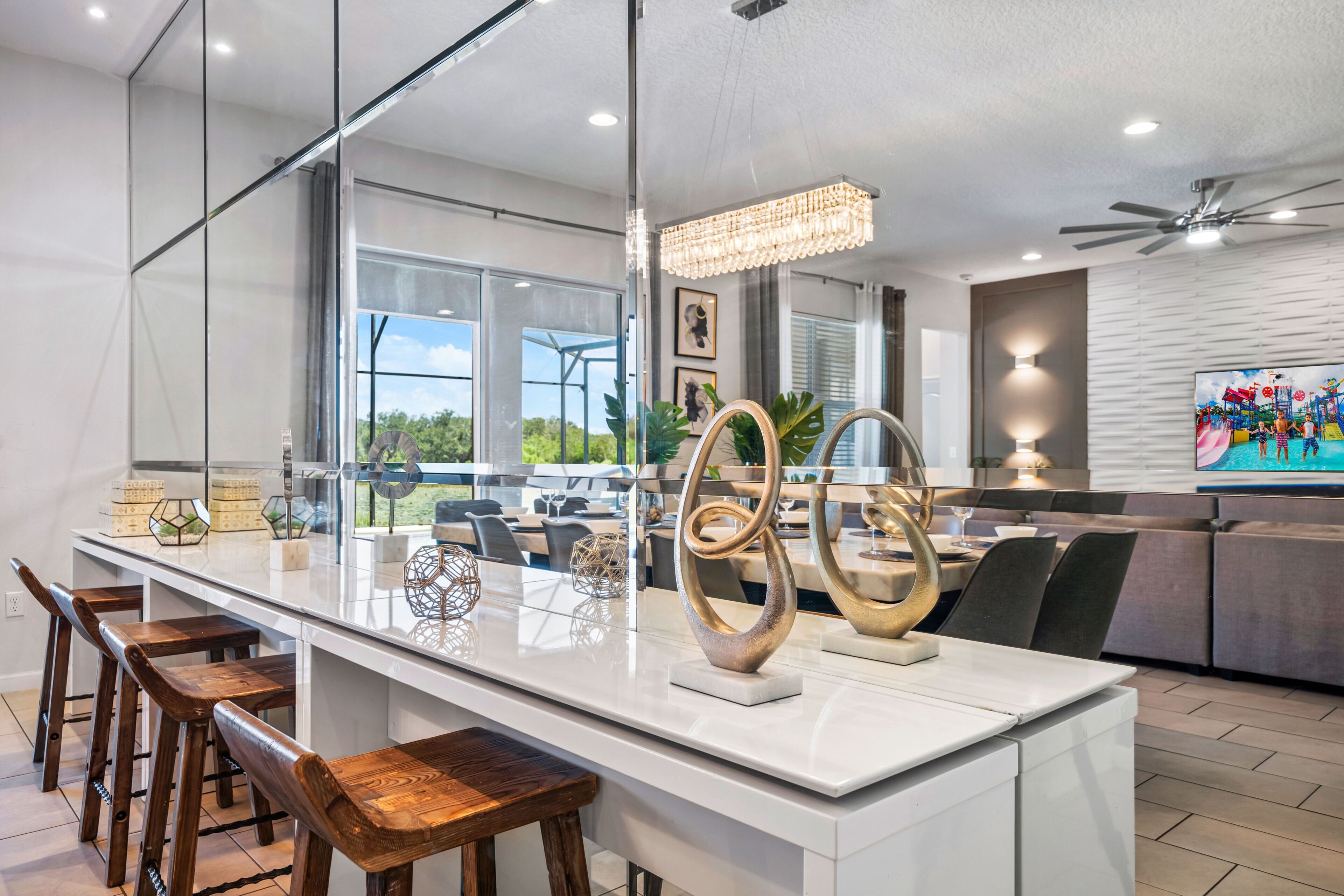 Een moderne keuken met een groot eiland, barkrukken en decoratieve objecten.