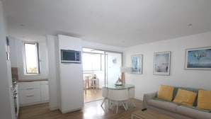 Un appartement moderne doté d’une kitchenette, d’un coin repas et d’un salon avec un canapé et des œuvres d’art.