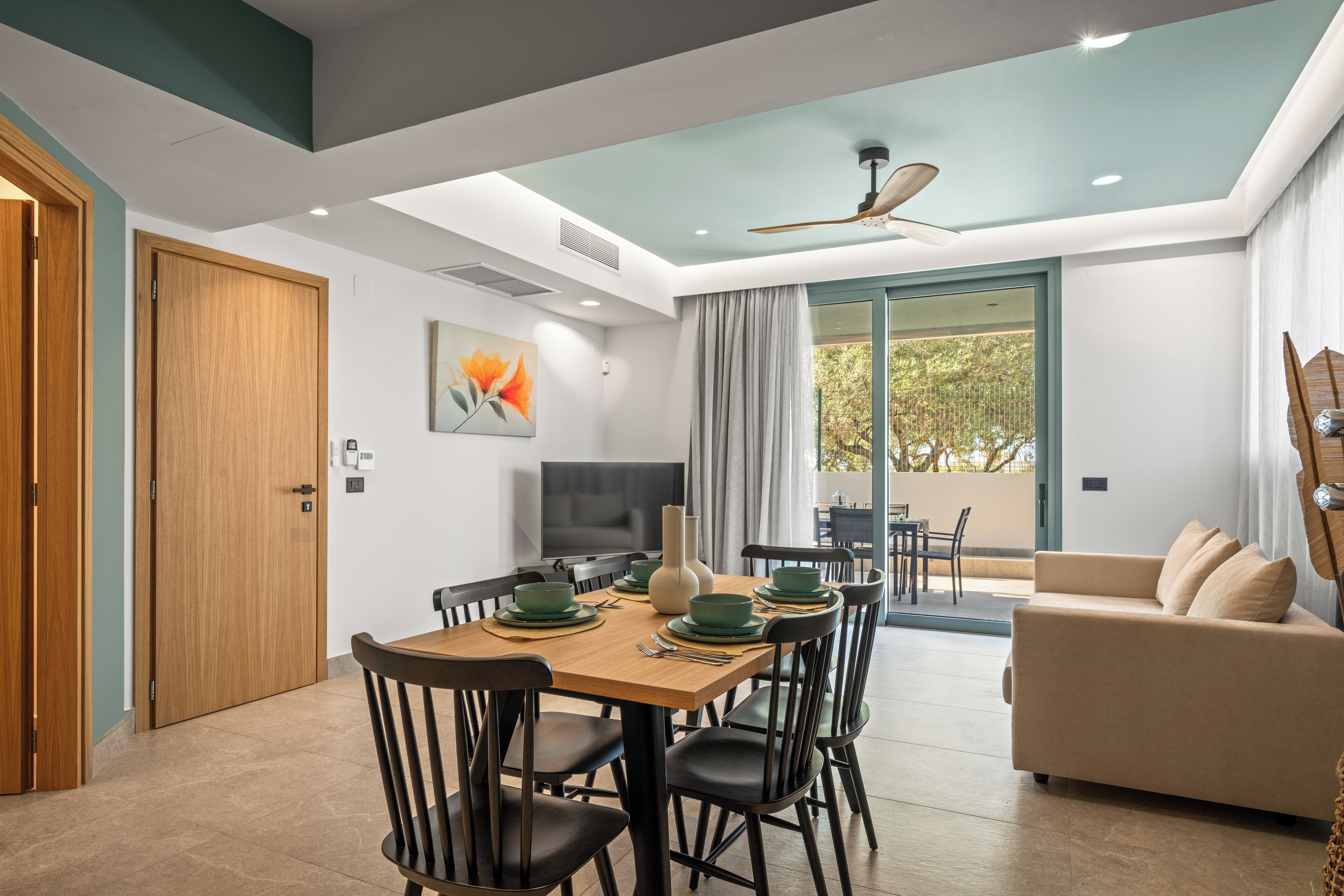 Un salon moderne comprenant un coin repas, un canapé et un ventilateur de plafond.