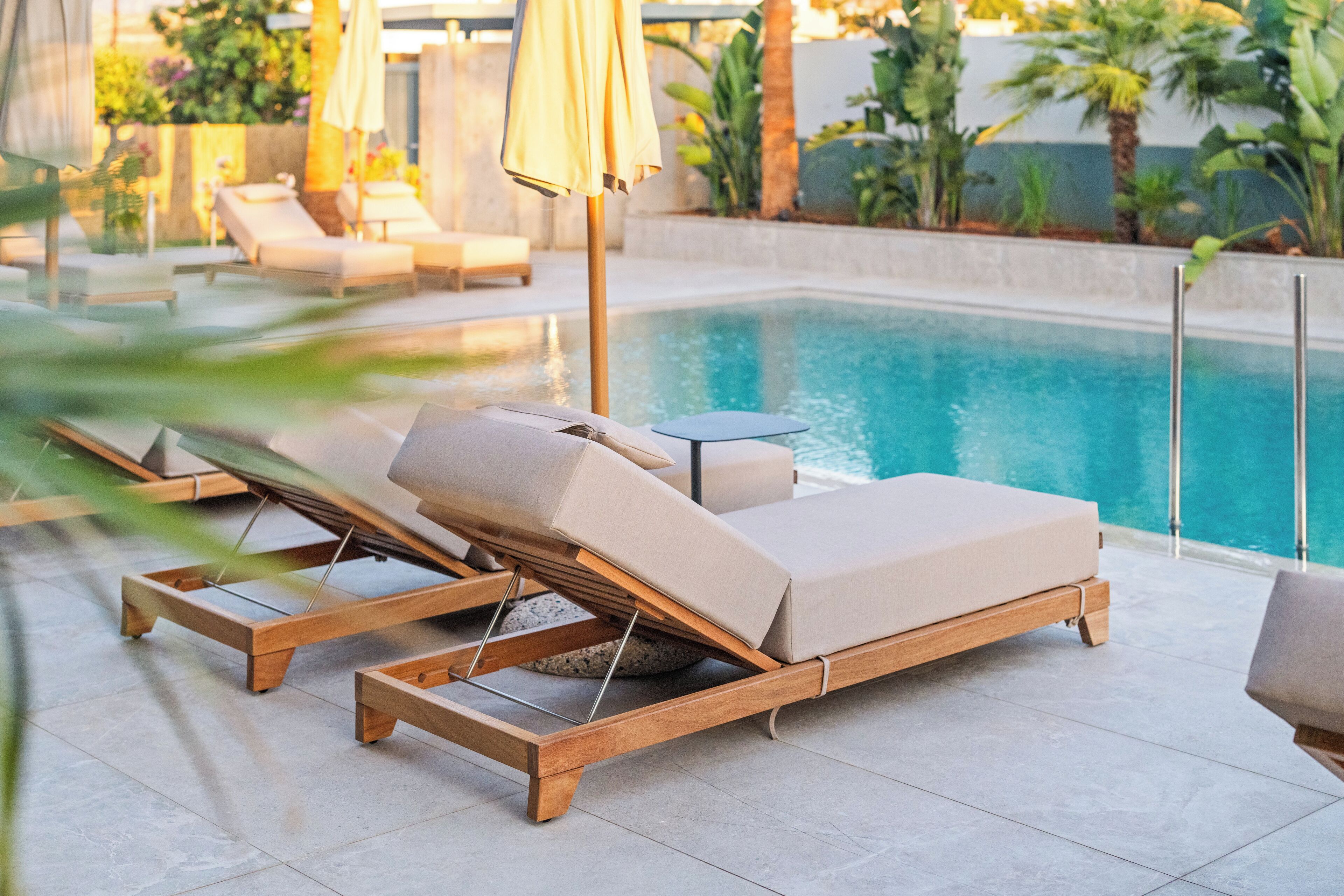 A poolside area with lounge chairs and umbrellas.