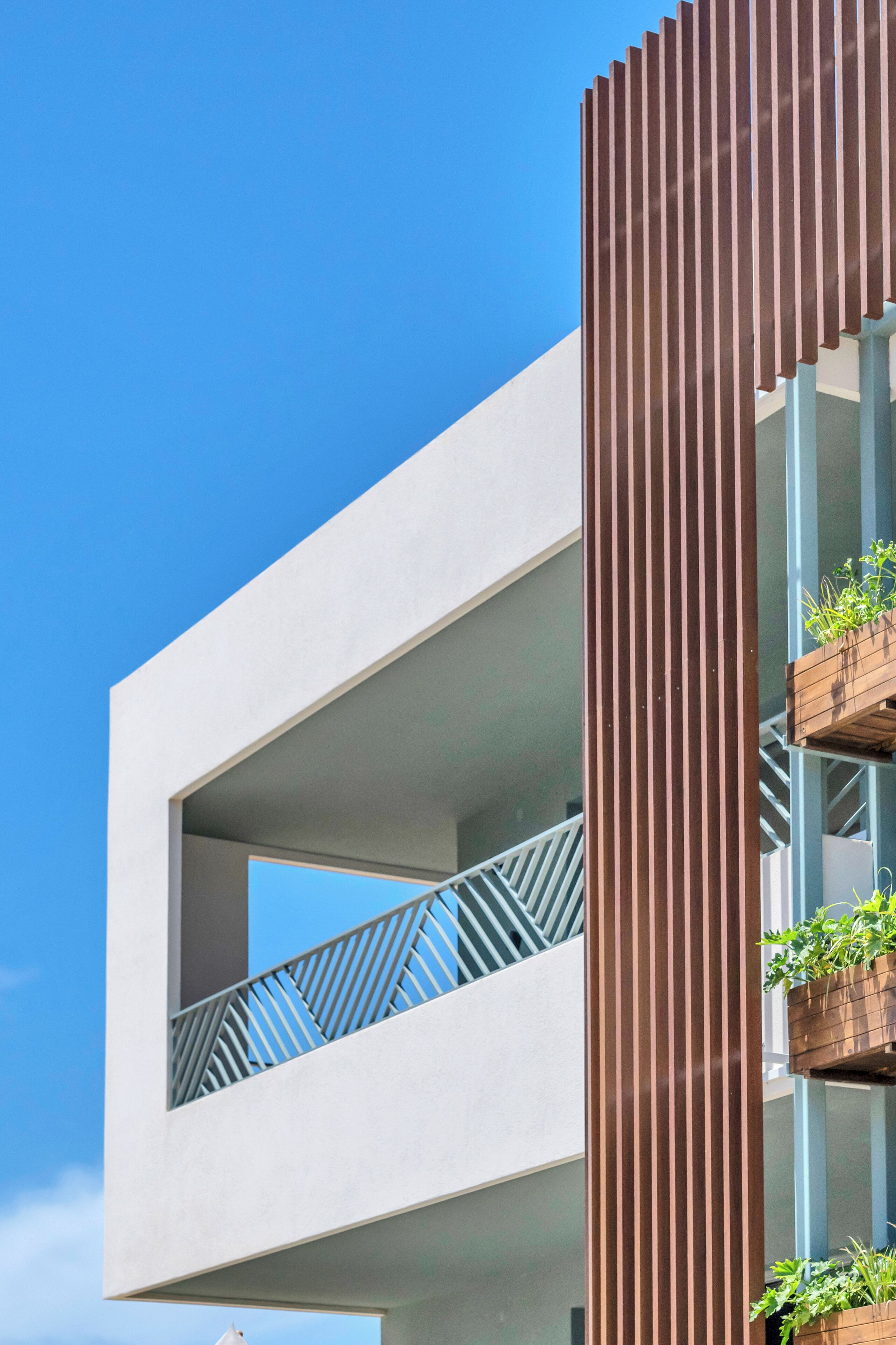 A modern building with a balcony and vertical wooden slats.
