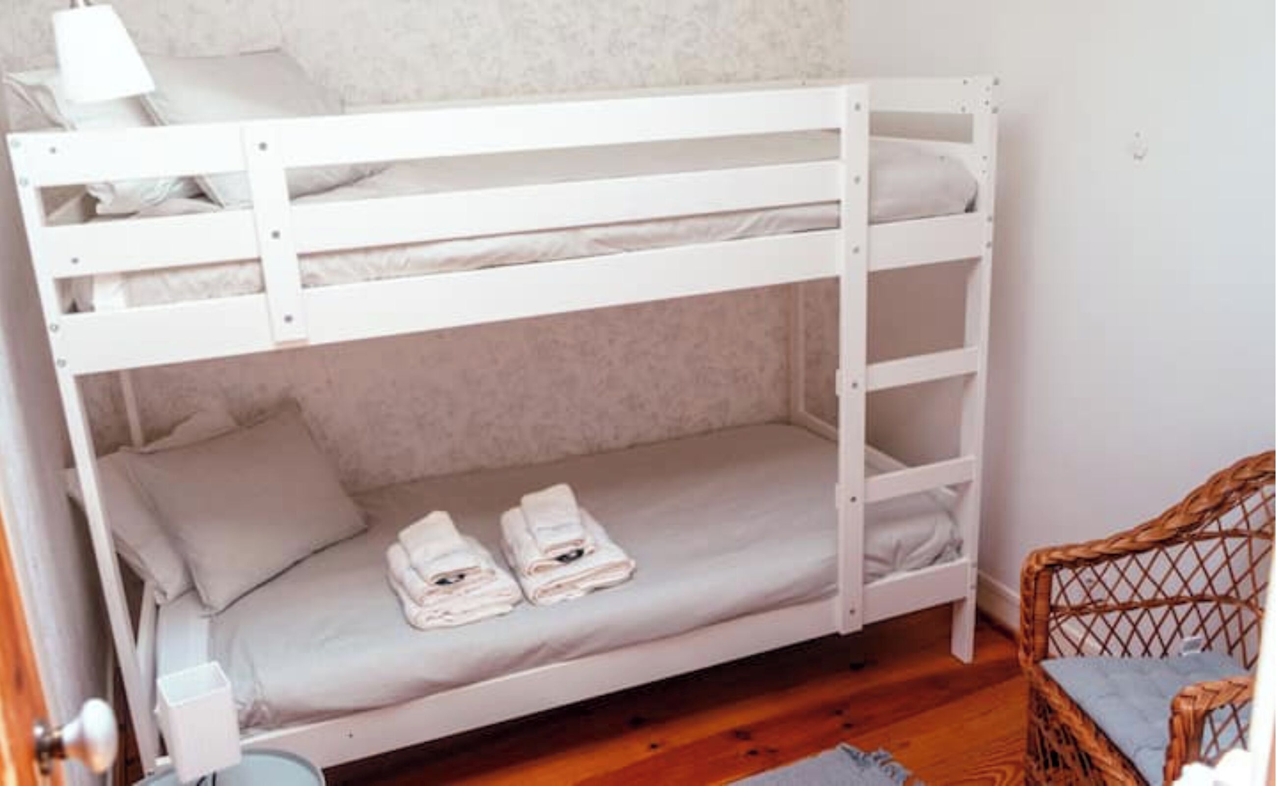 Una cama litera con una cama inferior y un colchón en ella. Hay dos toallas enrolladas en la cama inferior.