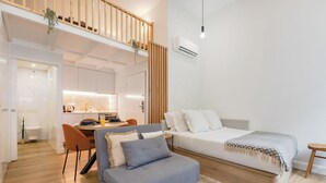 Un appartement moderne avec une chambre en mezzanine, un coin repas et une cuisine.