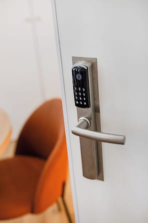 A modern door with a numeric keypad lock and a lever handle.