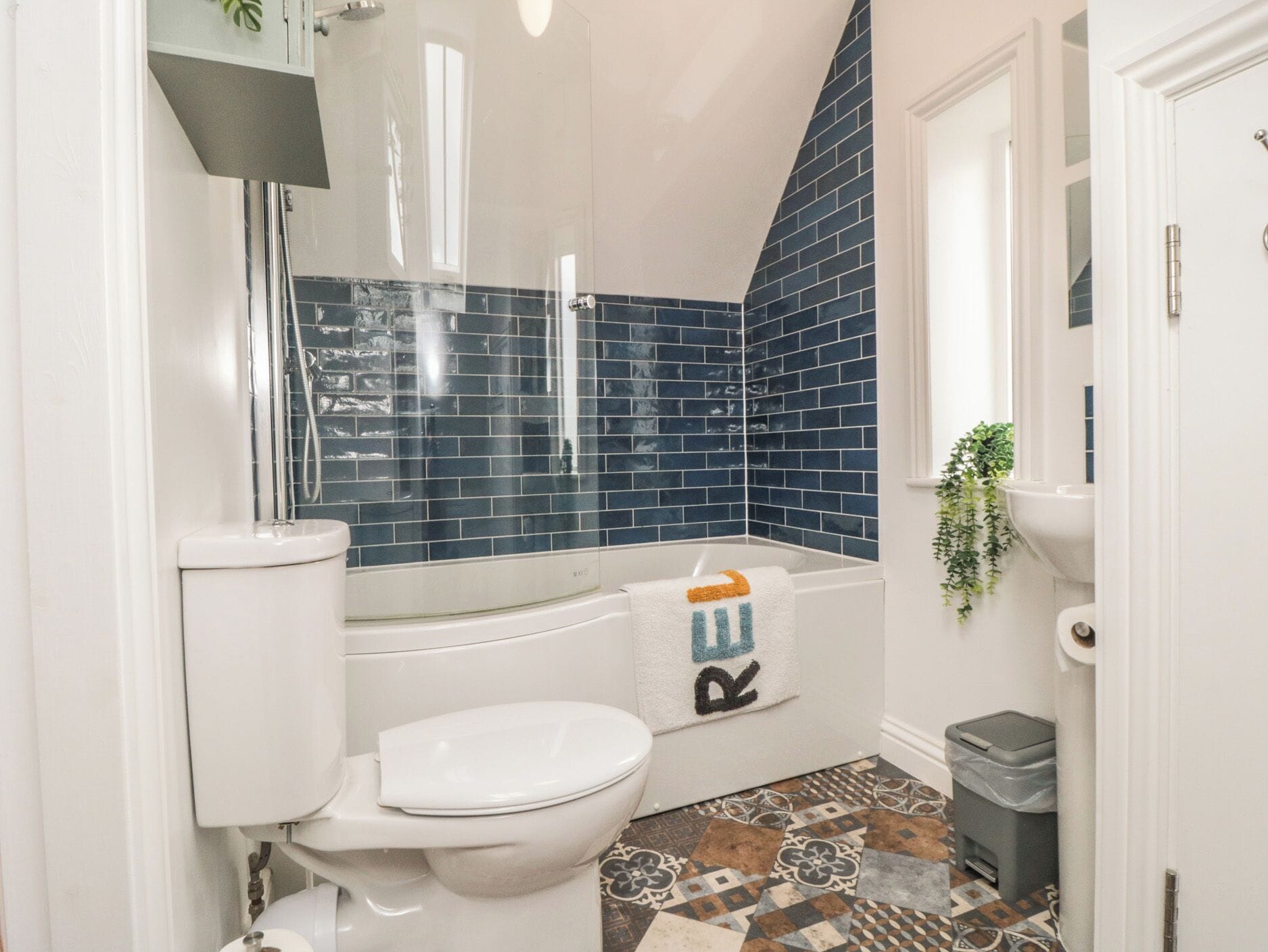 A bathroom with a white toilet, a bathtub, and a shower area.
