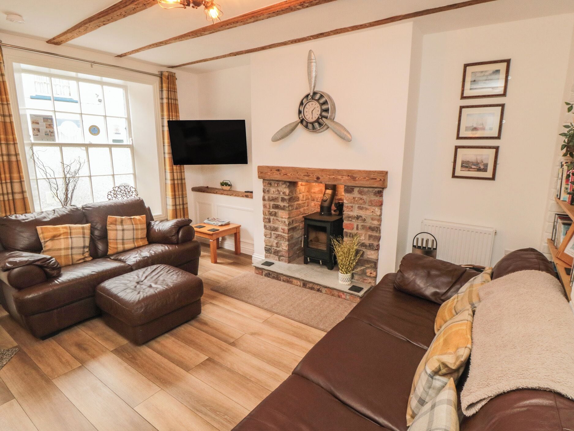 A cozy living room with a fireplace, leather sofas, and a flat-screen TV.