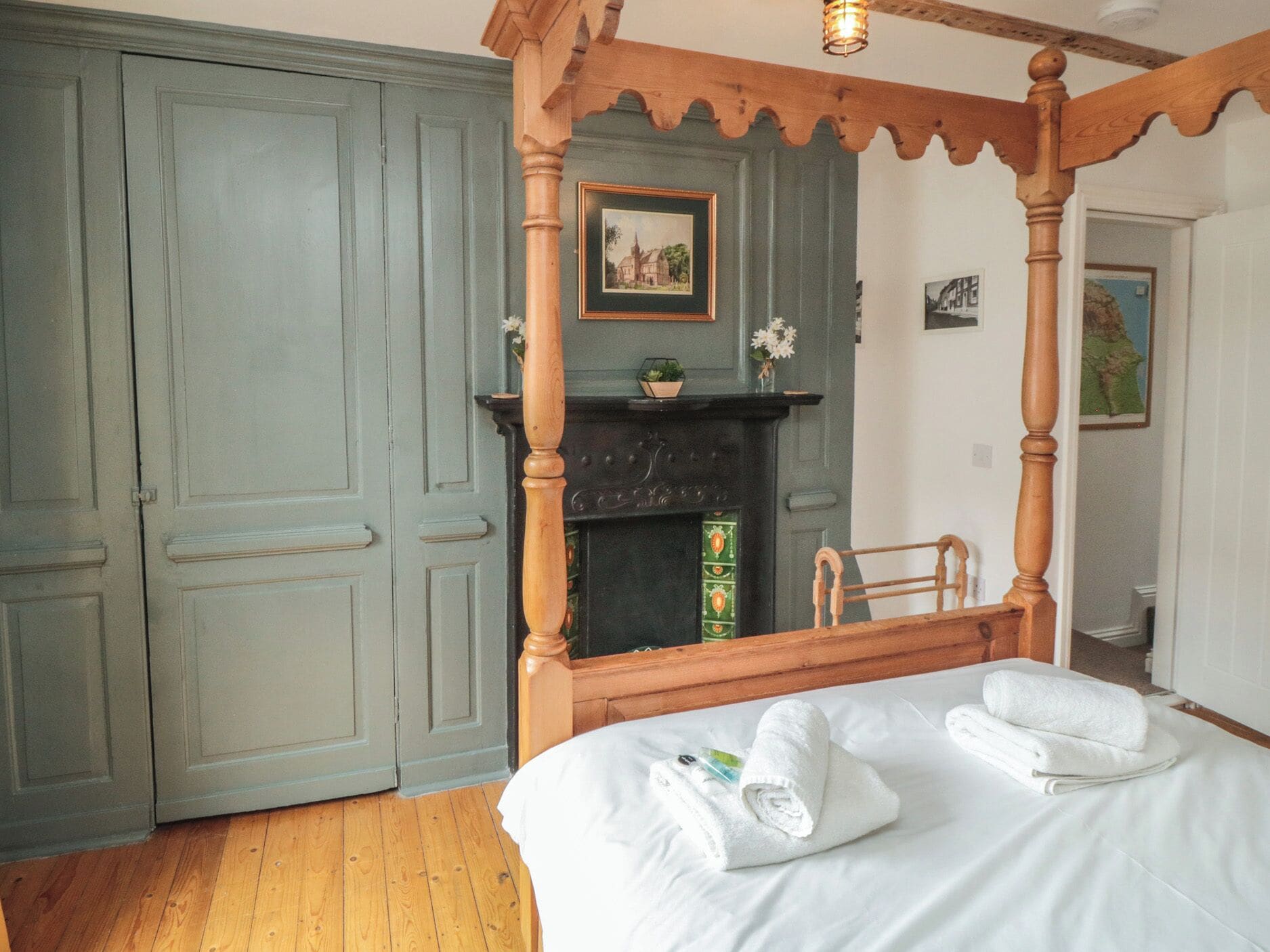 Quarto com cama de dossel, lareira e guarda-roupa grande.