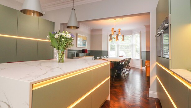 A modern kitchen with a marble countertop, pendant lighting, and a central island. - The Oakroyd (Carnforth)