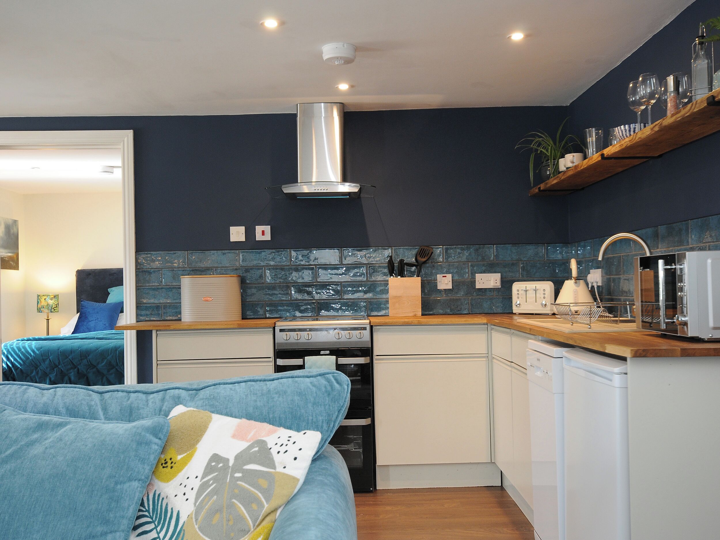 A modern kitchen with a stove, dishwasher, and a wooden countertop.