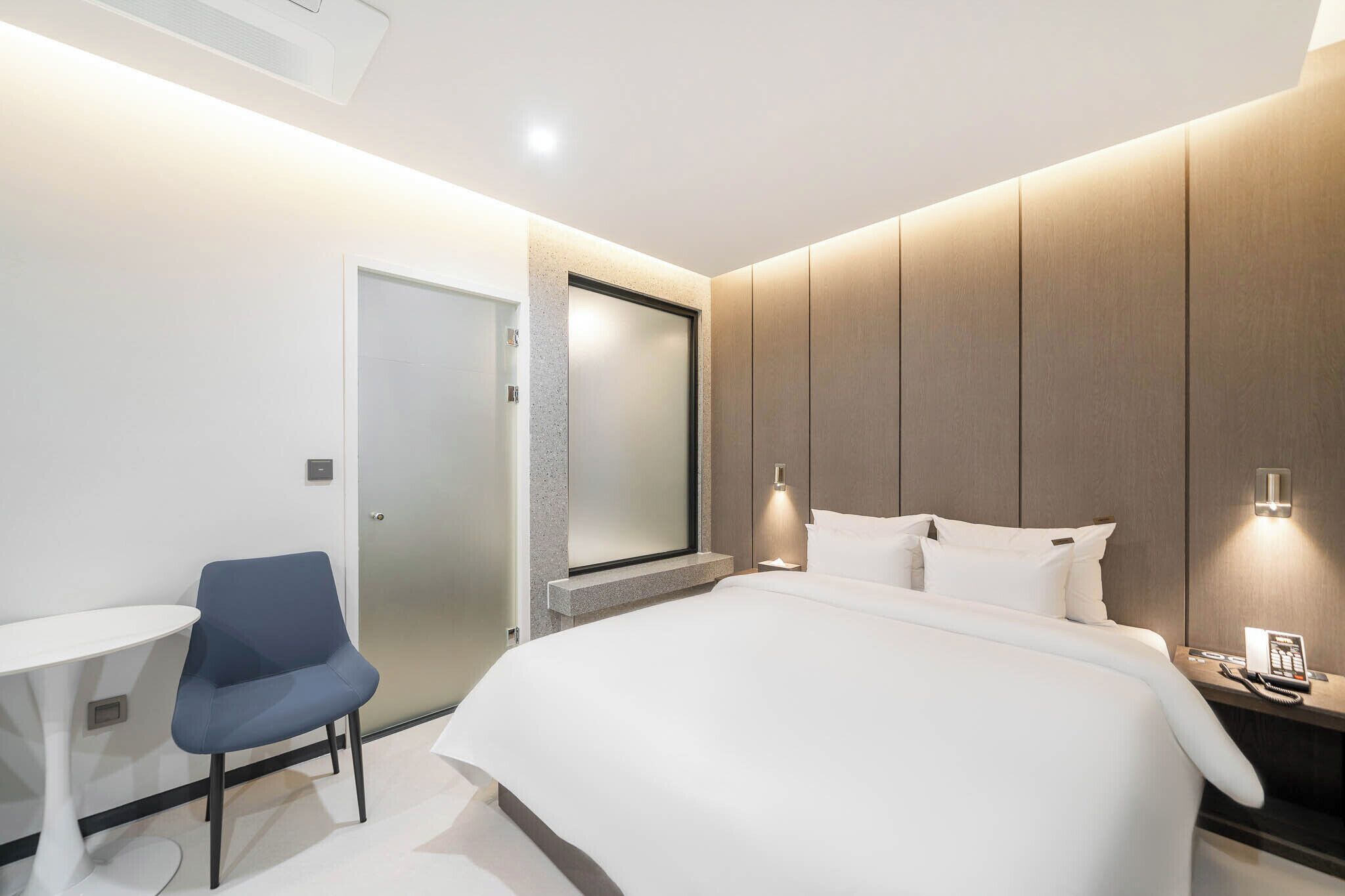 Une chambre d’hôtel moderne équipée d’un lit, d’un bureau et d’une chaise.