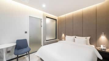 Una habitación de hotel moderna con cama, escritorio y silla.